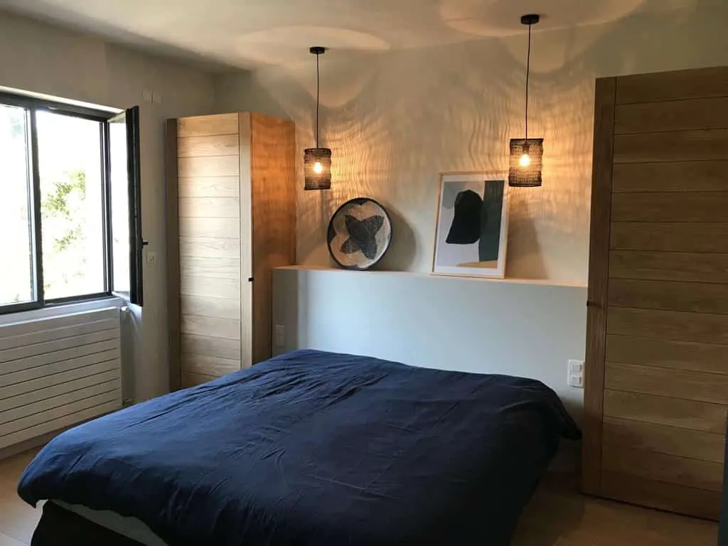 Chambre avec deux armoires en chêne et suspensions noires